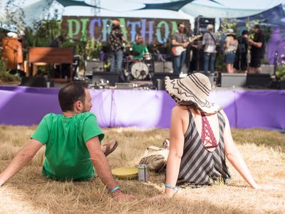 Two people relax on the lawn at 2019's festival.